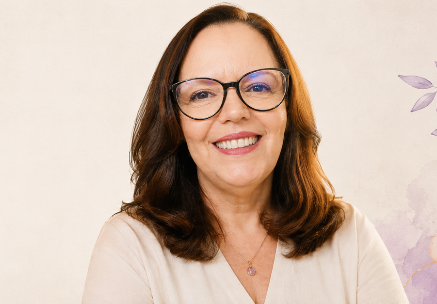 Ivana Raisky sorrindo, de óculos e blusa clara, em retrato de frente